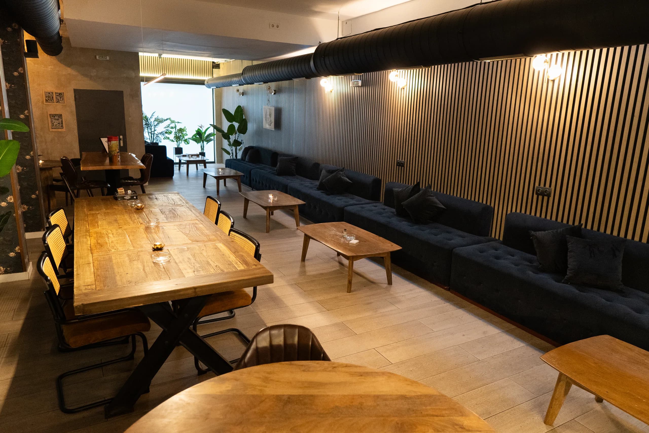 Mesa larga de madera y sofás de High Class Ibiza Weed Club